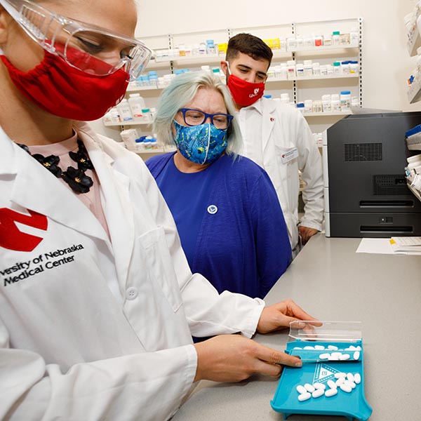 Pharmacy students and faculty in a simulated pharmacy