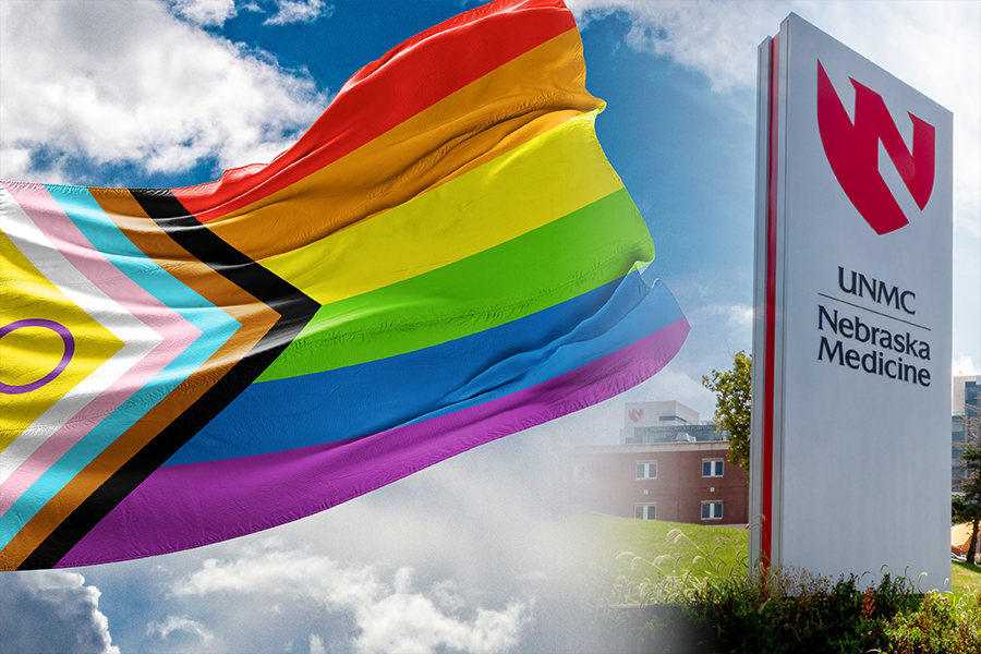 LGBTQ+ flag flies in the sky by a sign that says UNMC and Nebraska Medicine