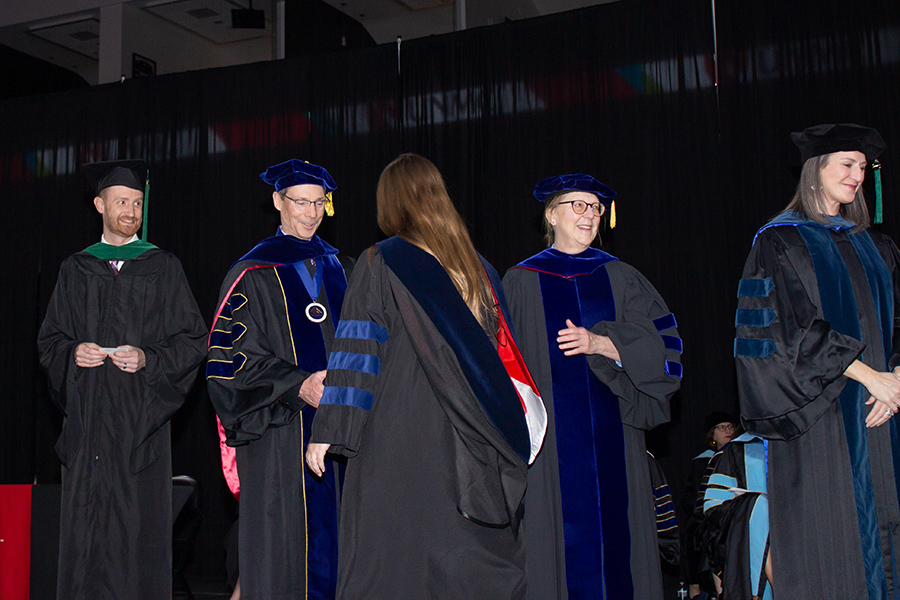 OT student hooded and shaking hands with dean