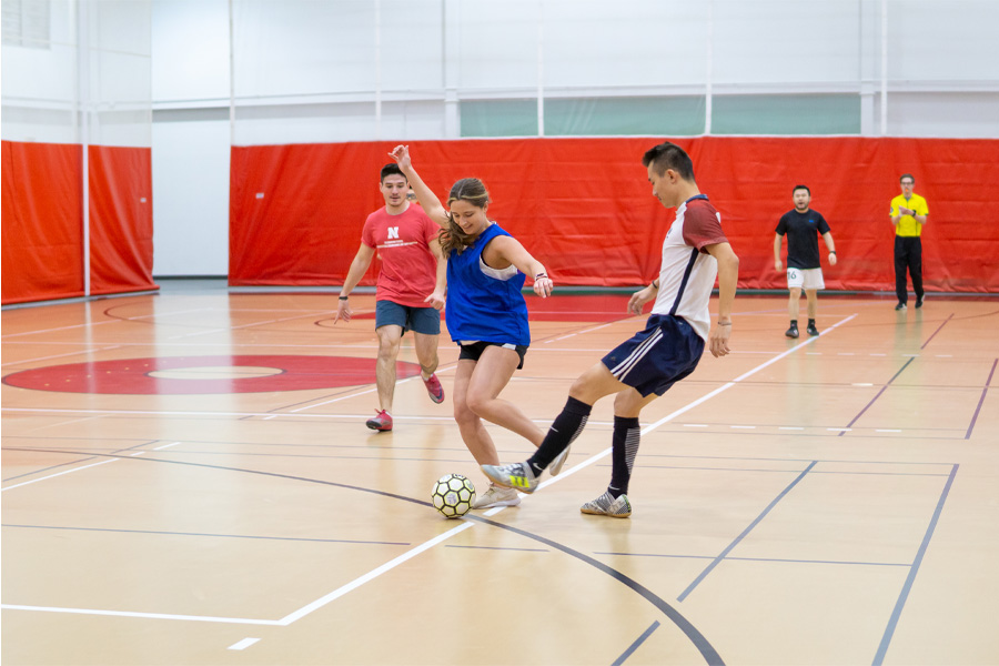 Students play soccer in a gymnasium