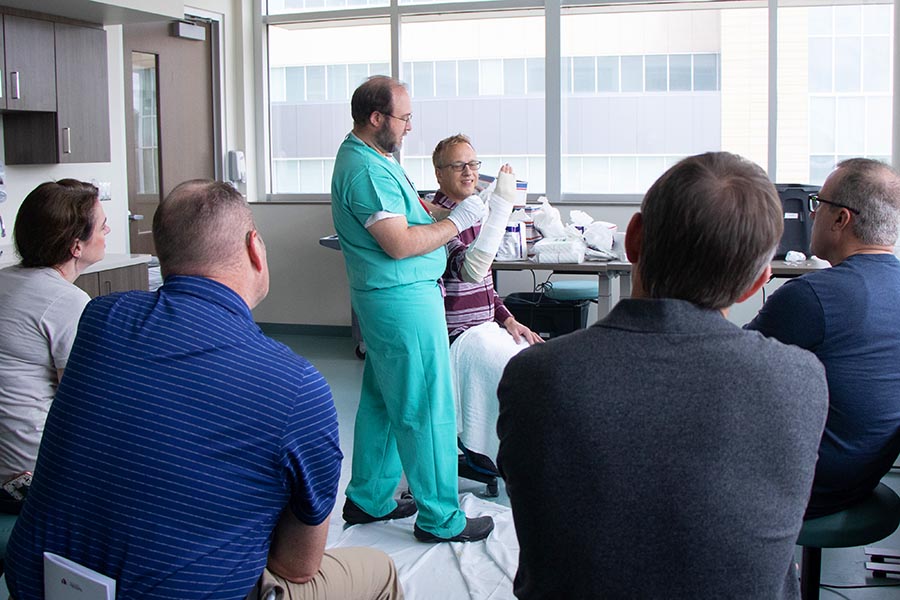 A UNMC faculty member shows program participants best practice for casting an arm. 