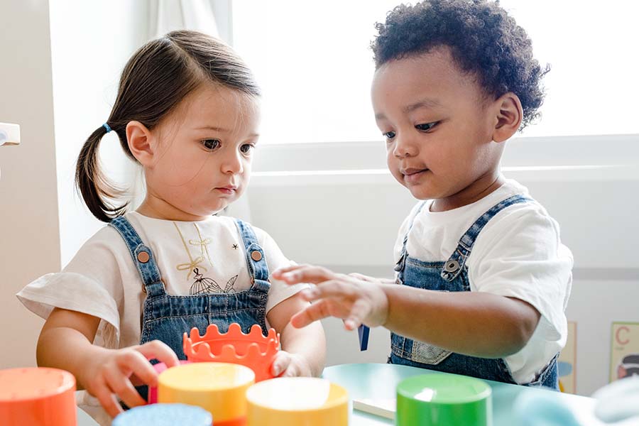 Young children playing with toy cups