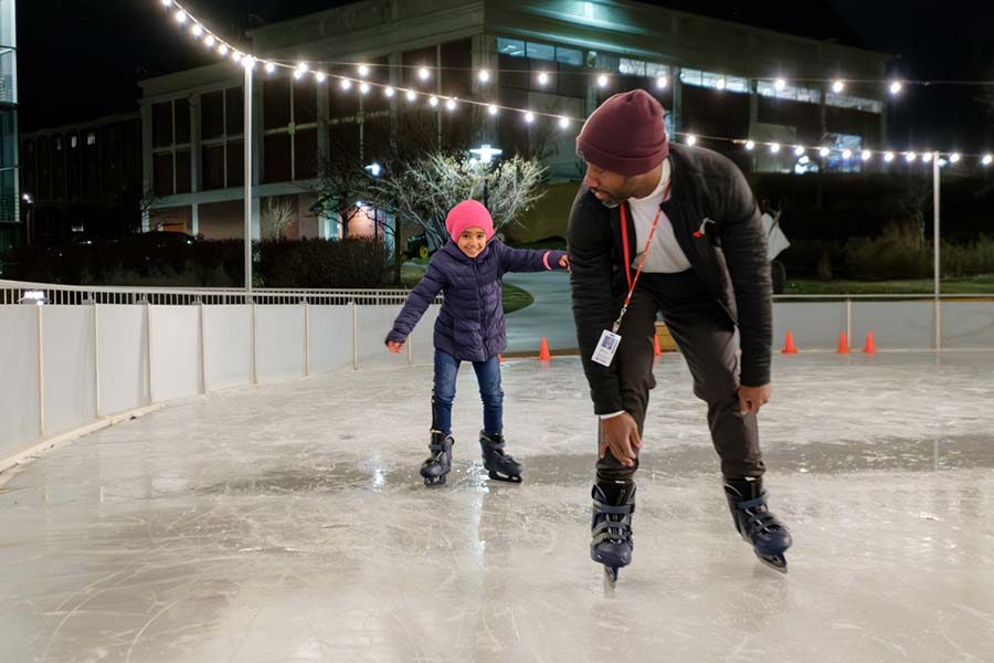 A UNMC faculty member and his daughter ice skate on the UNMC ice rink.