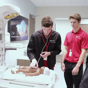 high school students learning neonatal care skills