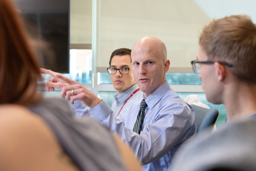 A UNMC faculty member meeting with a group of trainees