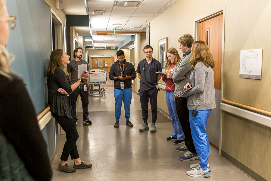 A group of Internal Medicine residents rounding with a female faculty member.