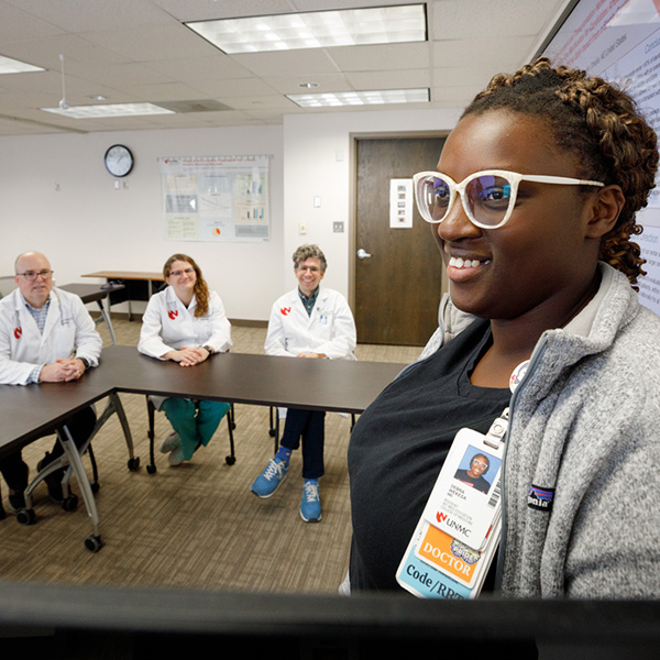 Three providers listen to a presentation by a nephrology fellow.