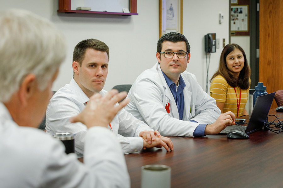 The chief of the UNMC Division of Rheumatology presents an educational session to a group of trainees.