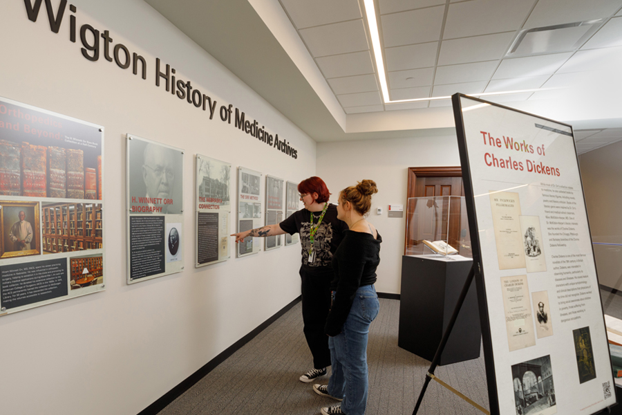 Student workers exploring an exhibition on Level 8 of McGoogan Library.