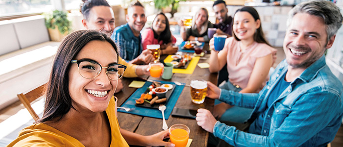 Group of adults around a table with drinks, credit iStock.