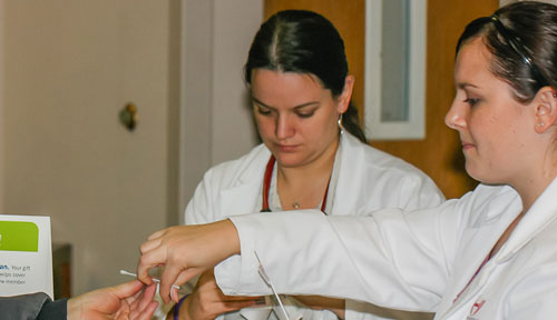 Medical students Andrea Mullen, left, and Lisa Leavitt take part in a bone marrow drive in 2010.