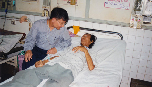 Dr. Paul Tran visiting a patient in an emergency room in Vietnam.
