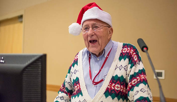 Robert Binhammer, Ph.D., leads a crowd in a holiday sing-along on Dec. 12.