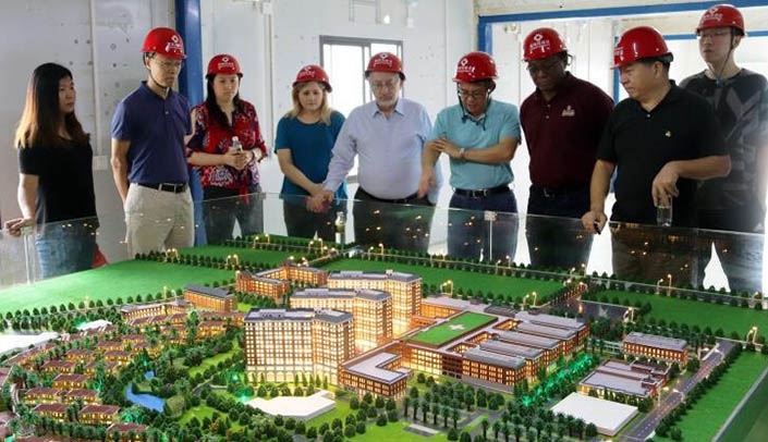 Members of the UNMC delegation and several Chinese officials view a model of the Chaotan Bay International Hospital.