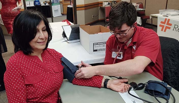 UNMC nursing student Patrick Nitchals takes Maria Alvizar's blood pressure.