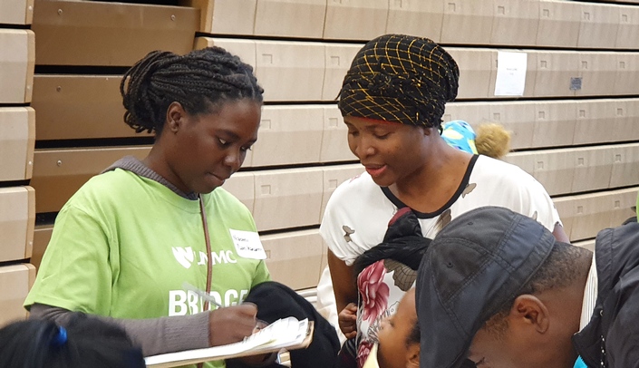 UNMC College of Public Health student, Na-Omi Hassane Dan Karami helps a French-speaking family during the annual Fall Refugee Health Fair held last year. The health fair is organized by public health students and is one of the many activities being recognized by the Association of Schools and Programs of Public Health.