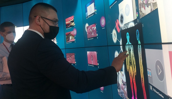 Douglas County Commissioner Roger Garcia tries out the Helix wall during his tour of the Davis Global Center.
