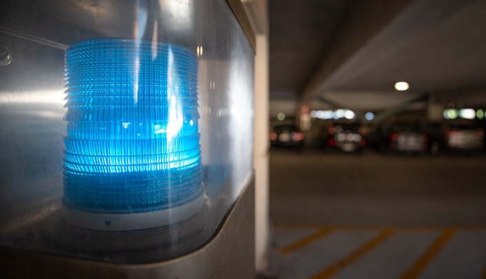 A blue emergency light inside the lot 50 parking garage. Campus safety was the focus of Thursday's chancellor's forum.
