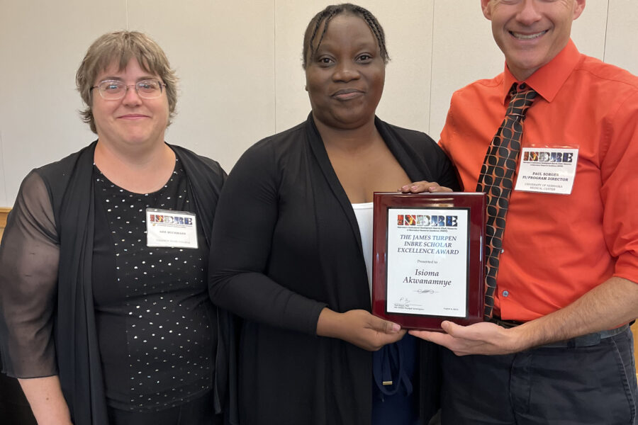 Dr&period; Paul Sorgen&comma; far right&comma; presents the James Turpen INBRE Scholar Excellence Award to Isioma Akwanamnye&comma; a senior at Chadron State College&period; Standing next to Isioma is her mentor&comma; Dr&period; Ann Buchmann&period;