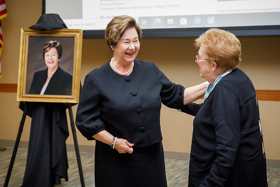 Dean Juliann Sebastian&comma; PhD&comma; and her mentor Carolyn Williams&comma; PhD&comma; react to a portrait of Dr&period; Sebastian unveiled during the retirement event&period;