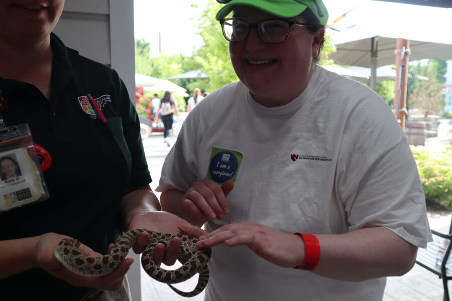 Georgia Ryba touches a snake during a respite outing at Omaha&apos;s Henry Doorly Zoo & Aquarium&period;