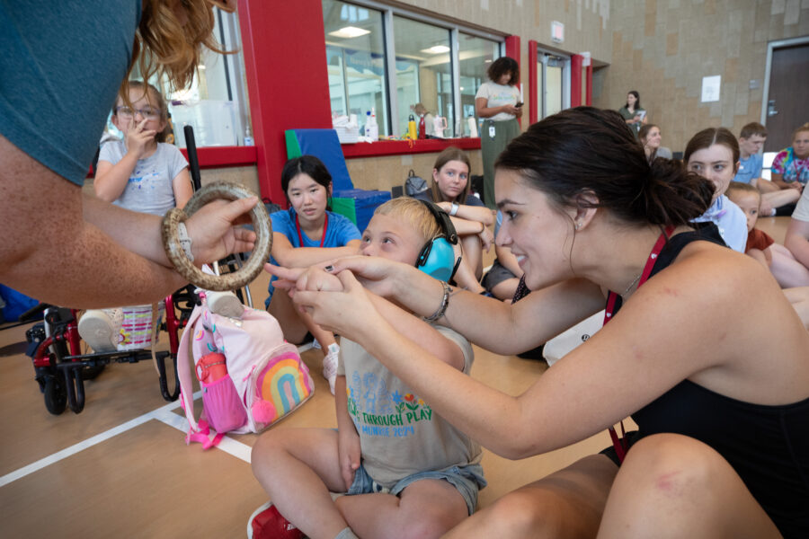 A camper gets help from a buddy to touch a snake during a visit from Wildlife Encounters&period;