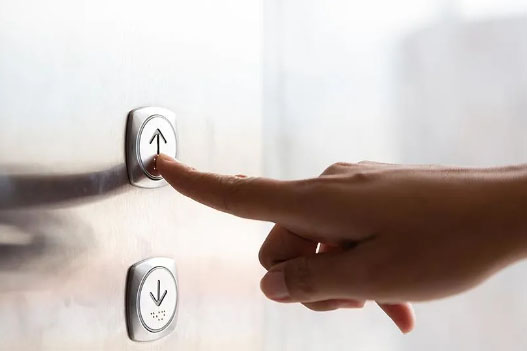 Finger pressing an elevator button