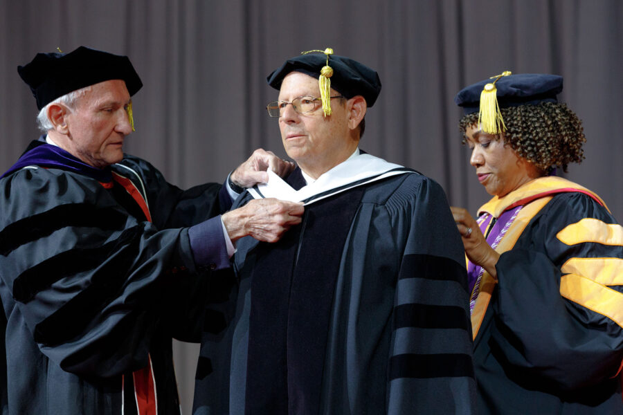 Barry Gold&comma; PhD&comma; receives an Honorary Doctorate of Science degree at the May 2024 UNMC commencement from University of Nebraska Regent Jack Stark and  Lepaine Sharp-McHenry&comma; DNP&comma; dean of the UNMC College of Nursing&period;