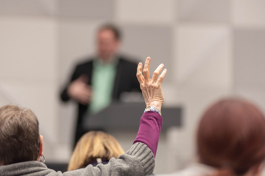 Person asking a question at an educational symposium&period;