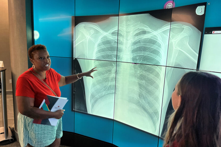 Legislative candidate Ashlei Spivey&comma; at left&comma; experiences one of the iEXCEL program&apos;s interactive digital iWalls on a tour given by Moriah McCune&comma; iEXCEL&apos;s community engagement coordinator&period;