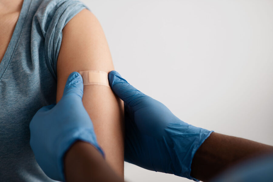 A patient receiving a bandage after a vaccination shot