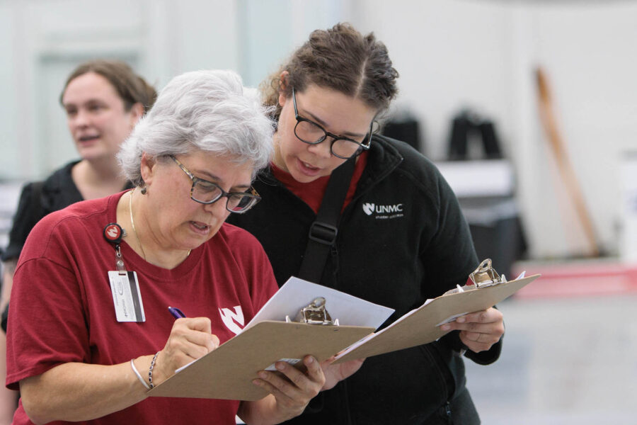 Barbara Breazeale&comma; seen here at a 2022 UNMC commencement&comma; is known for working the details of a commencement ceremony from her clipboard&period; "I&apos;ve always prided our ceremony on being a very professional-looking ceremony&comma;" Breazeale says&period;