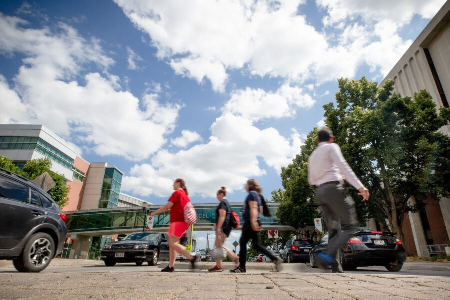 A group of people walking on a sidewalk