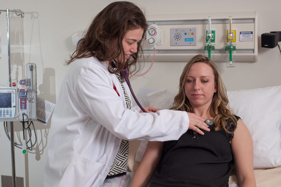 A PA sitting to consult with a patient