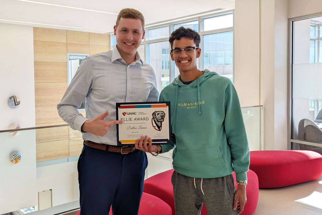 Drew Prescott, PharmD, assistant dean for student affairs in the UNMC College of Pharmacy, presents pharmacy student Dallon Lemon with the Ellie Award.