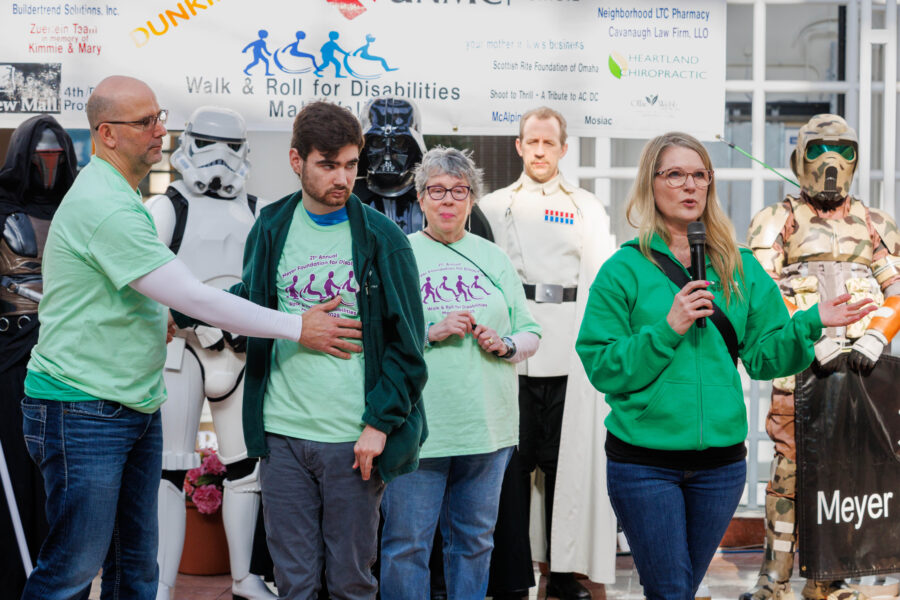 Heidi Sommer&comma; right&comma; speaks to participants as Mark and Hayden Sommer and Meyer Foundation President Mary McHale look on&period; The Sommers were the honorary advocated family at the Walk and Roll for Disabilities on March 2&period;