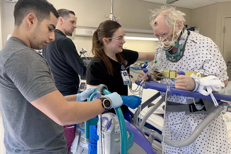 ICU Nurses helping a patient on ventilator stand at the bedside