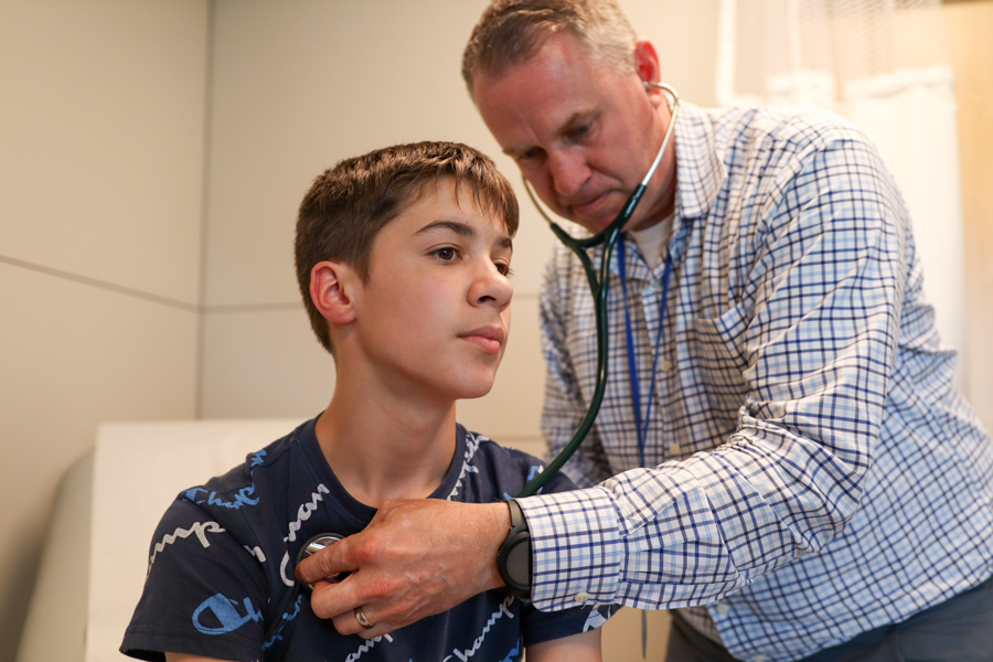 Dr. examining teen patient