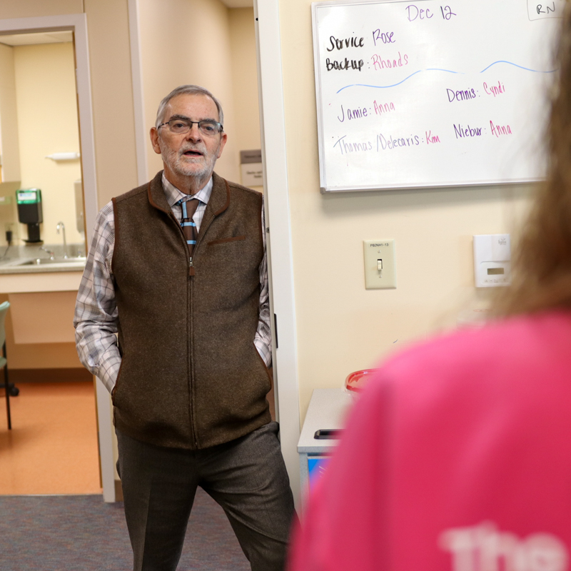 doctor speaking to unseen person while standing in a doorway