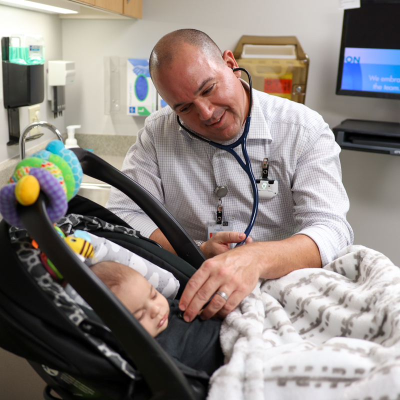 Dr. Johnathan Cramer examining baby