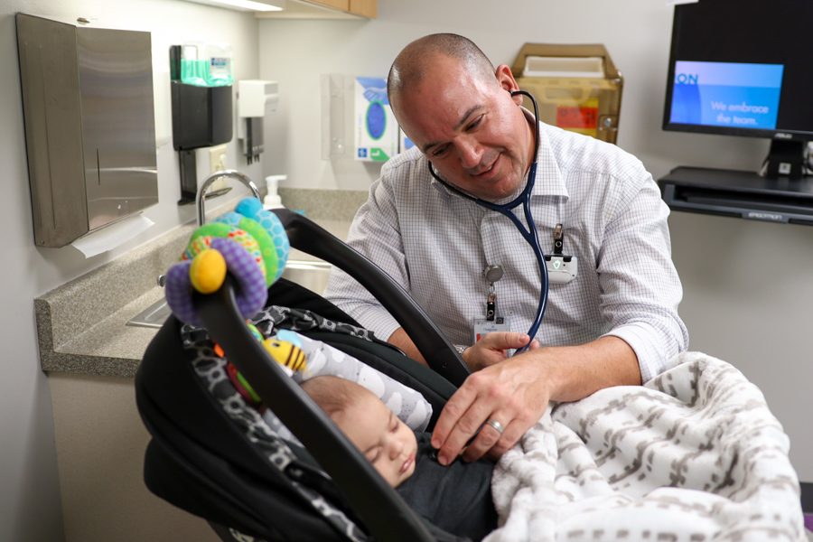 Dr. Johnathan Cramer examining infant