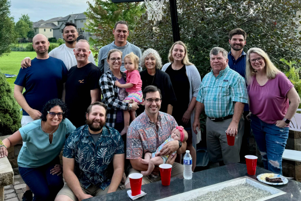 group of Emergency Medicine members and family posing together outside