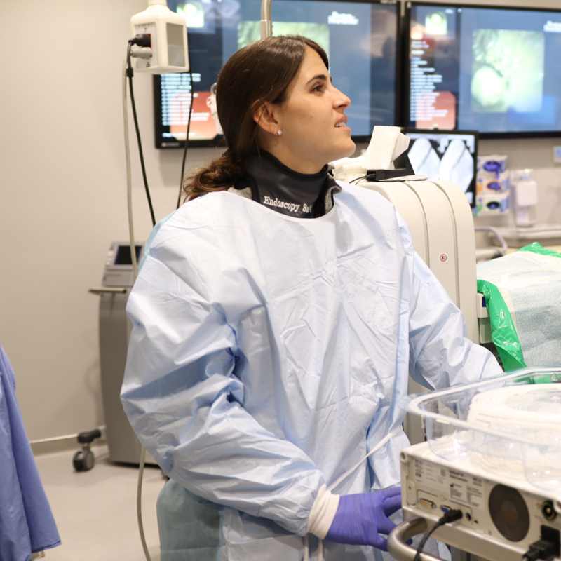 female fellow watching procedure in scrubs