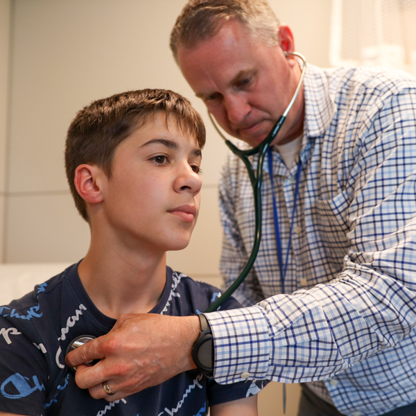 Doctor examining teen patient