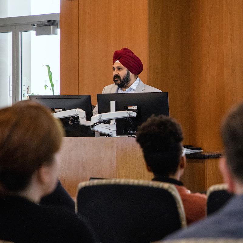 Photo of Manpreet Singh at a podium.
