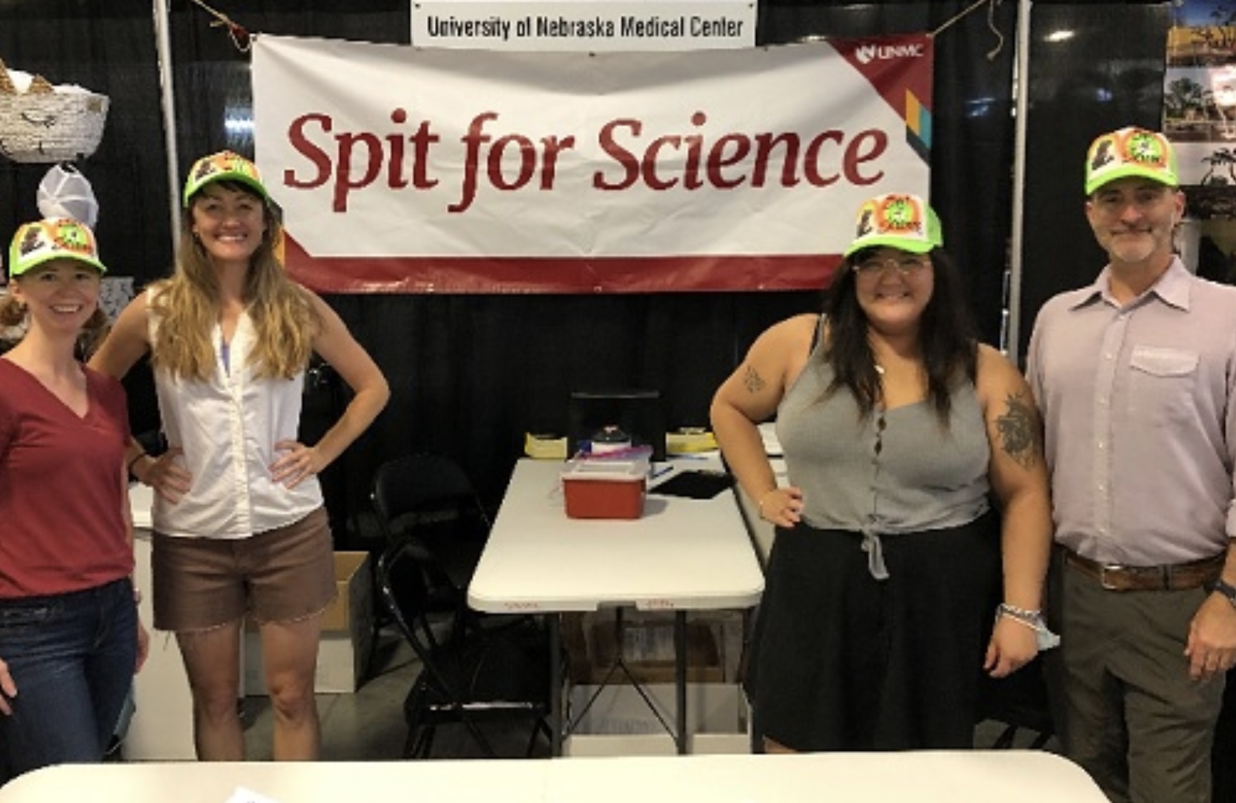 The research team posing in front of their booth "Spit for Science."