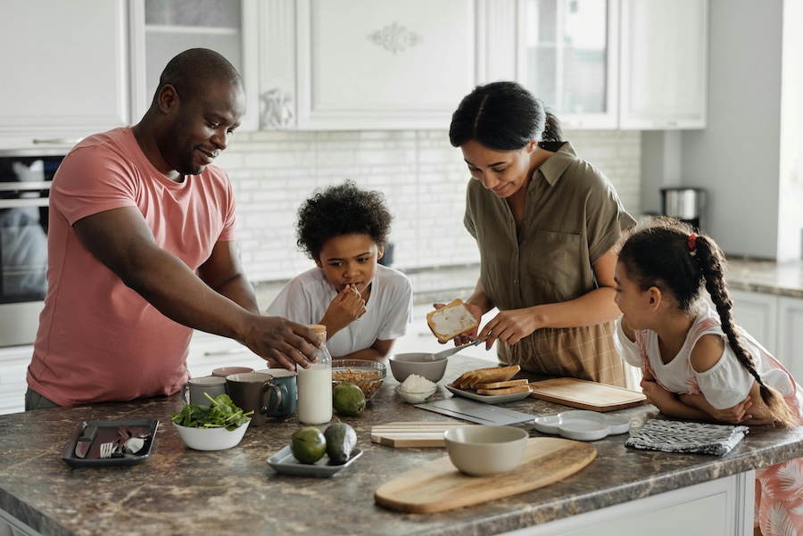 Family gathered together eating breakfast.