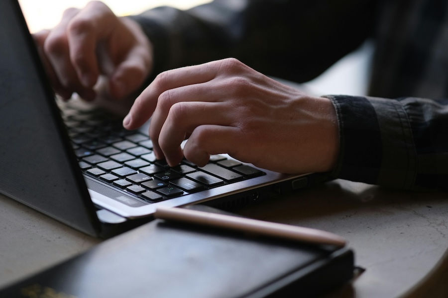 Hands typing on a laptop. 