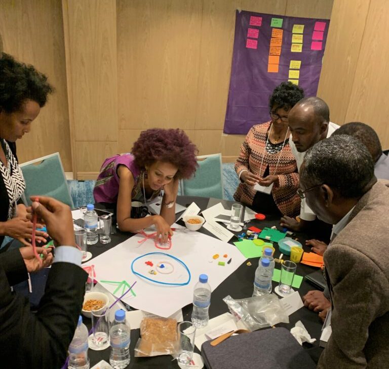 Image of conference participants working together on a project around a table.