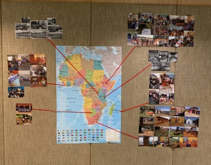 Map of Africa with photos around it on a wall.